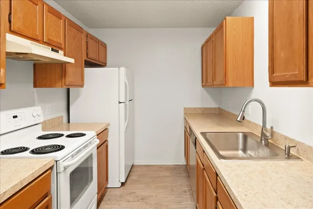 a kitchen with stainless steel appliances granite countertop a sink stove and refrigerator