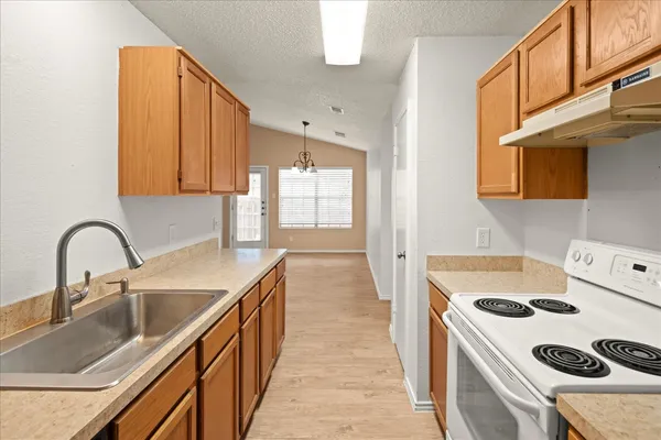 a kitchen with a sink a stove and cabinets
