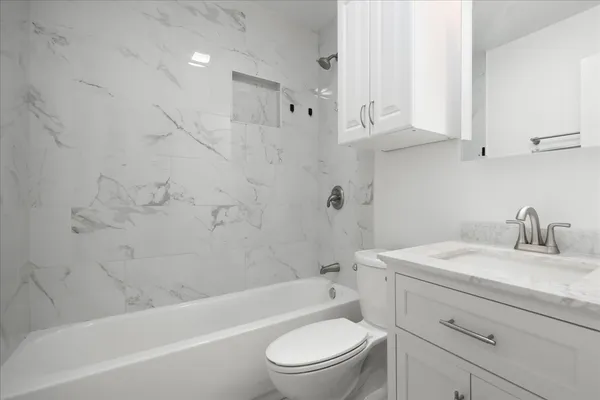a bathroom with a granite countertop toilet sink and bathtub