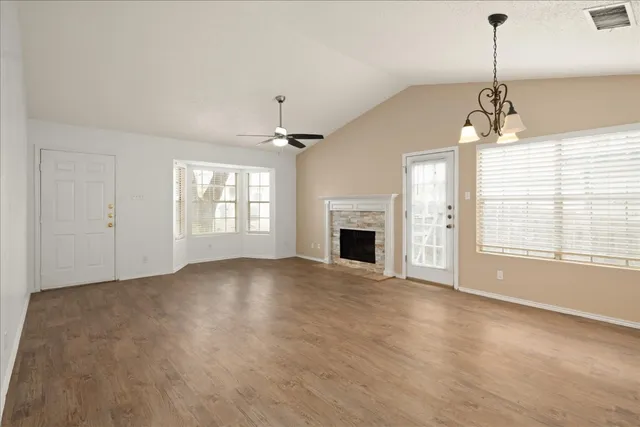 a view of empty room with fireplace and windows