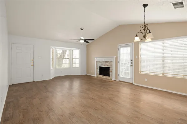 a view of empty room with fireplace and windows