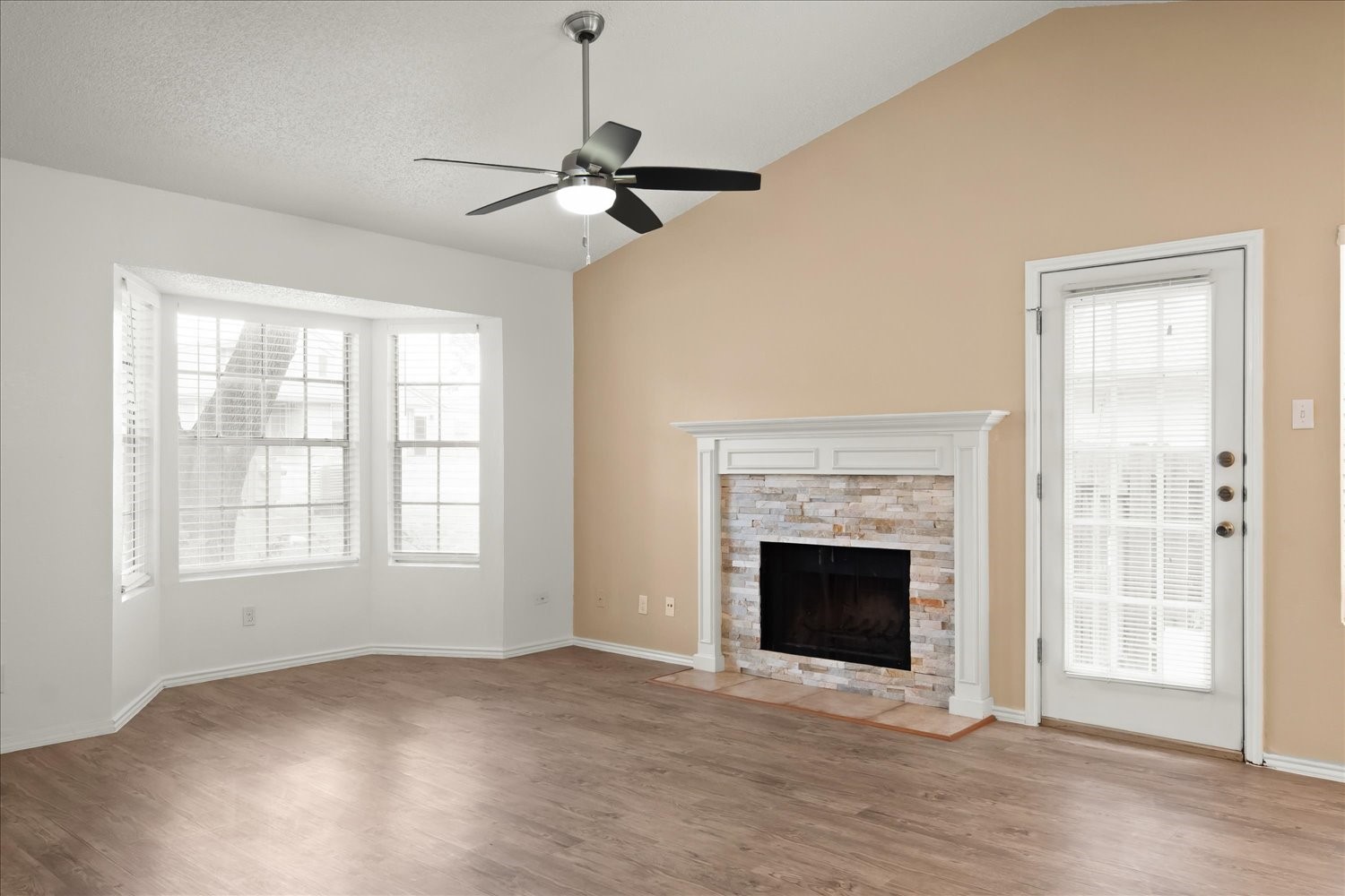 220 Sailmaster Street, Unit A Lakeway, TX 78734 - Photo 8 of 32 a view of an empty room with wooden floor fireplace and a window