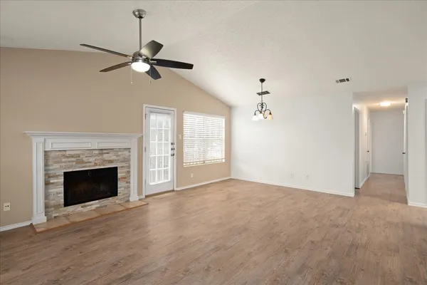 a view of an empty room with a fireplace and a window