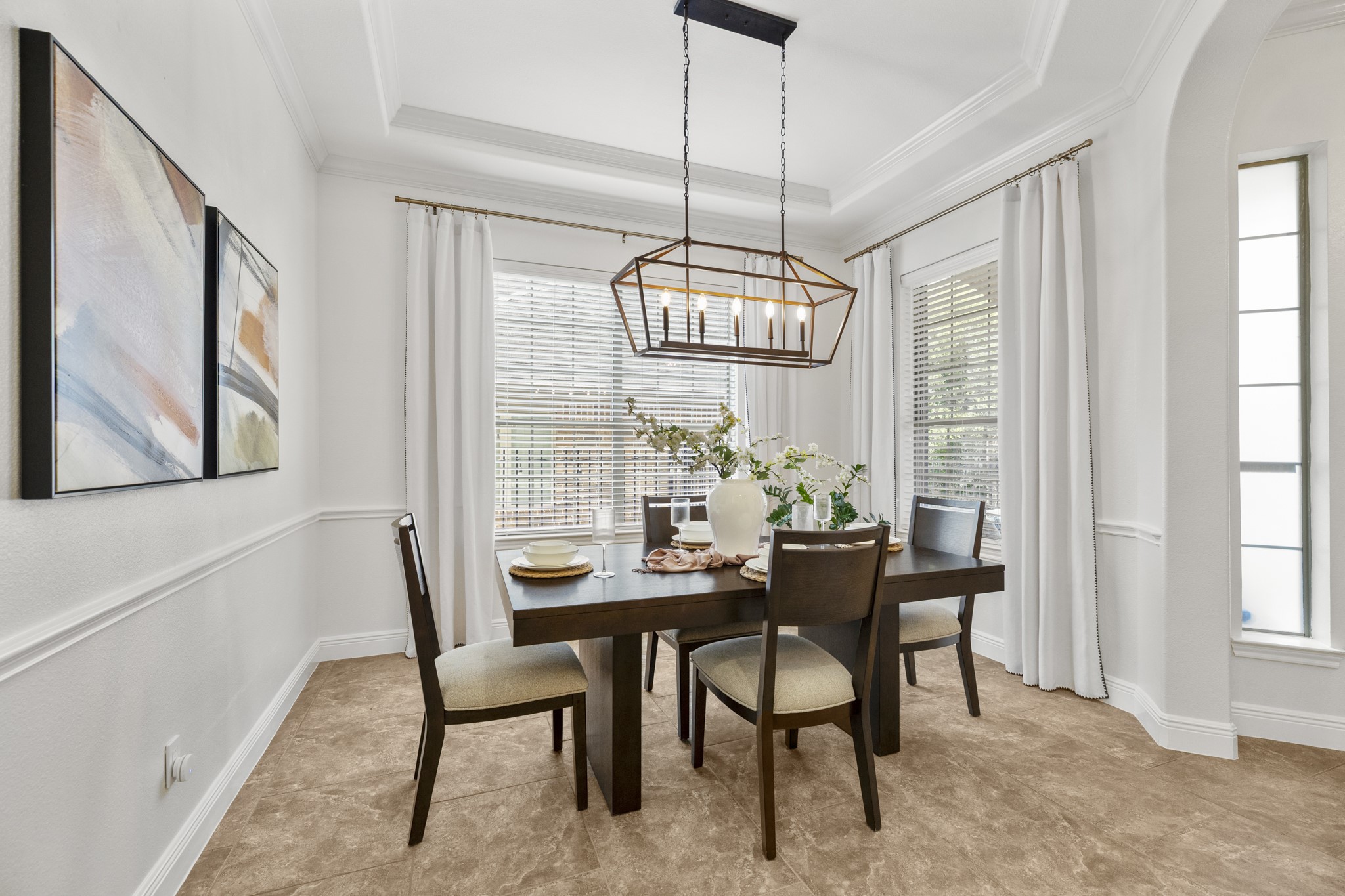 26 Winhall Place The Woodlands, TX 77354 - Photo 6 of 49 The dining area is light and bright with tray ceilings and beautiful millwork. Striking chandelier adds a touch of modern elegance.