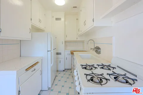a kitchen with a sink a stove and refrigerator