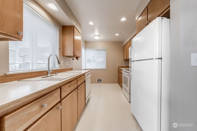 a kitchen with white cabinets and white appliances