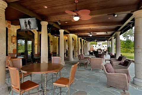 a outdoor space with lots of tables a large window and chairs