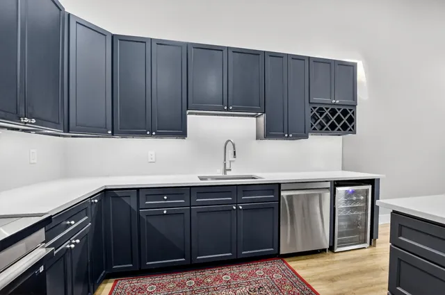 a kitchen with stainless steel appliances a table chairs refrigerator and wooden cabinets