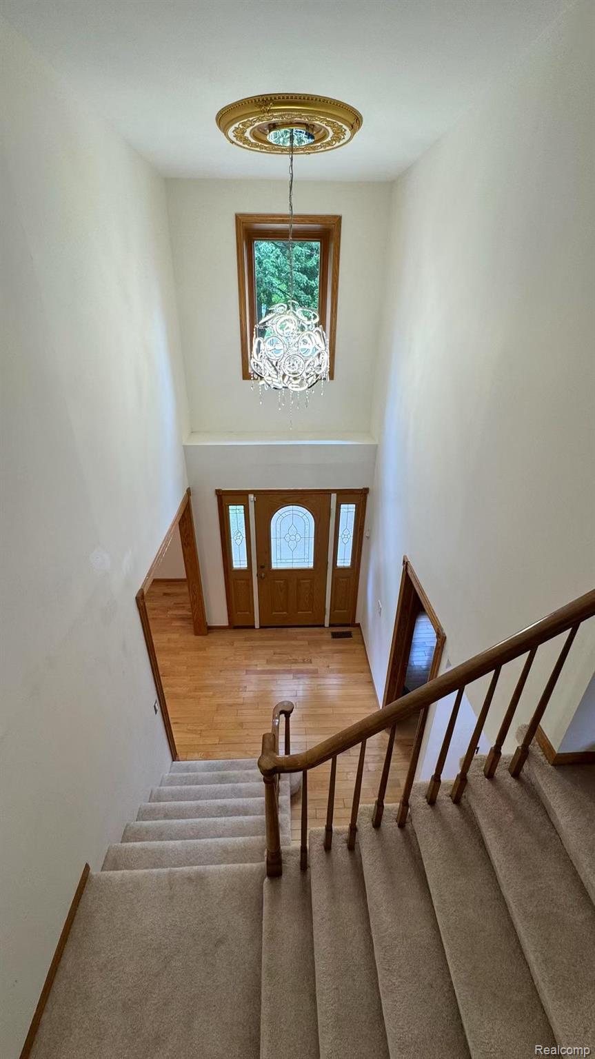 3440 Salem Drive Rochester, MI 48306 - Photo 19 of 33 Two-story foyer featuring an ornate ceiling medallion with a contemporary chandelier and an arched transom window