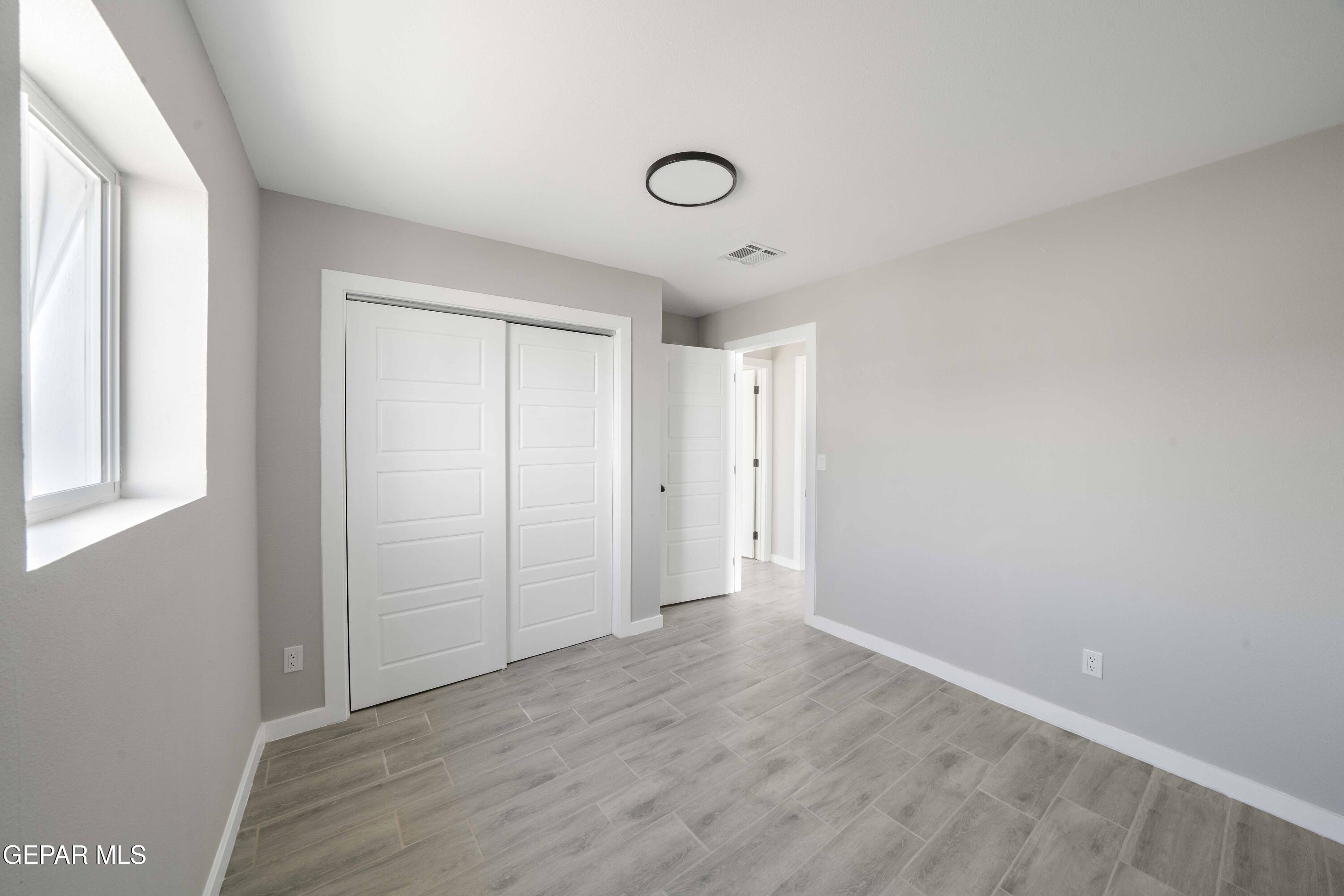 10752 Mellward Road Socorro, TX 79927 - Photo 12 of 37 an empty room with wooden floor and windows