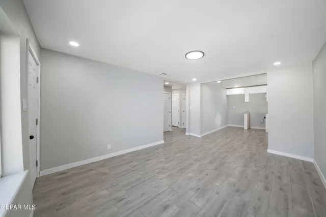an empty room with wooden floor and a window