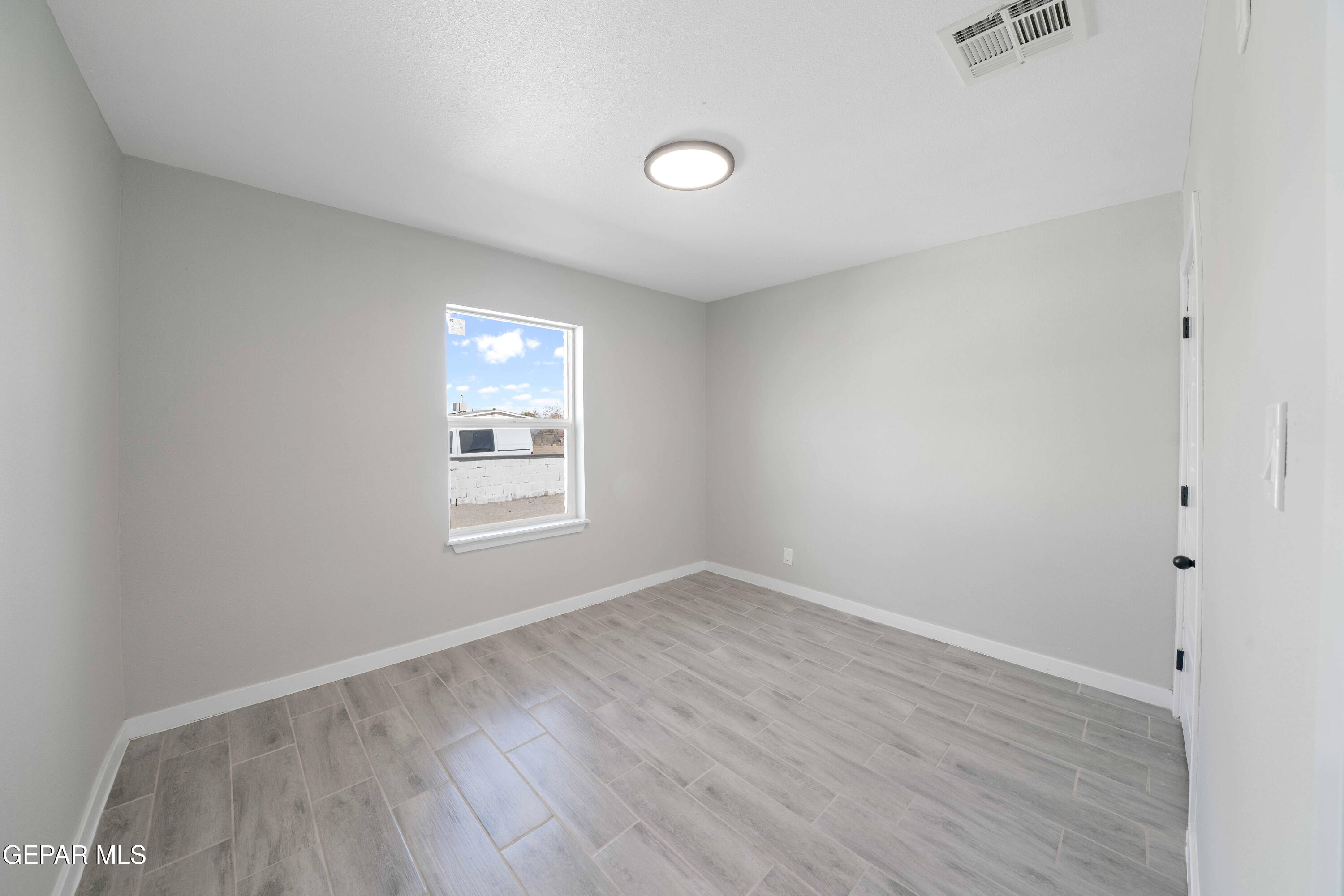 10752 Mellward Road Socorro, TX 79927 - Photo 20 of 37 an empty room with wooden floor and windows