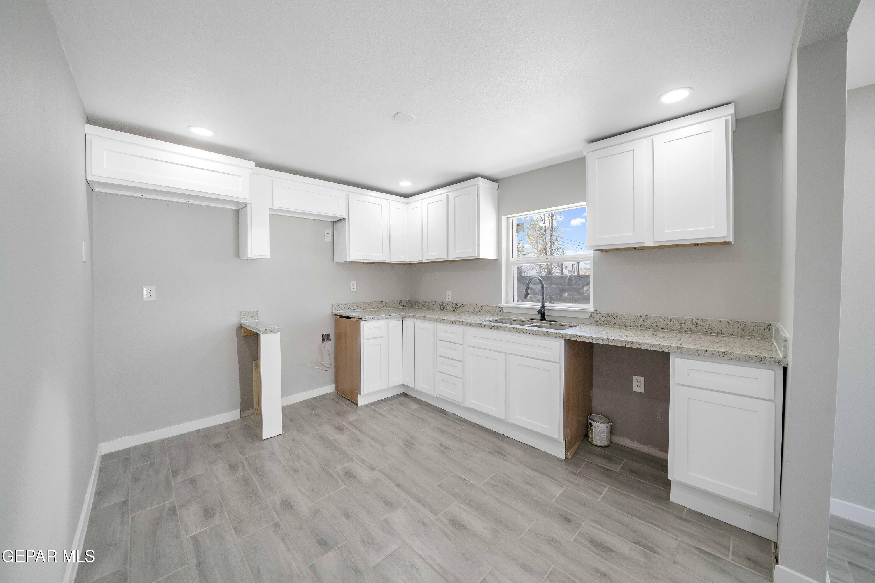 10752 Mellward Road Socorro, TX 79927 - Photo 21 of 37 a kitchen with a sink cabinets and wooden floor
