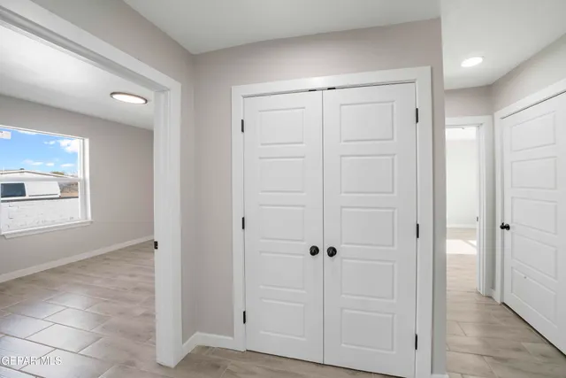 an empty room with windows and closet