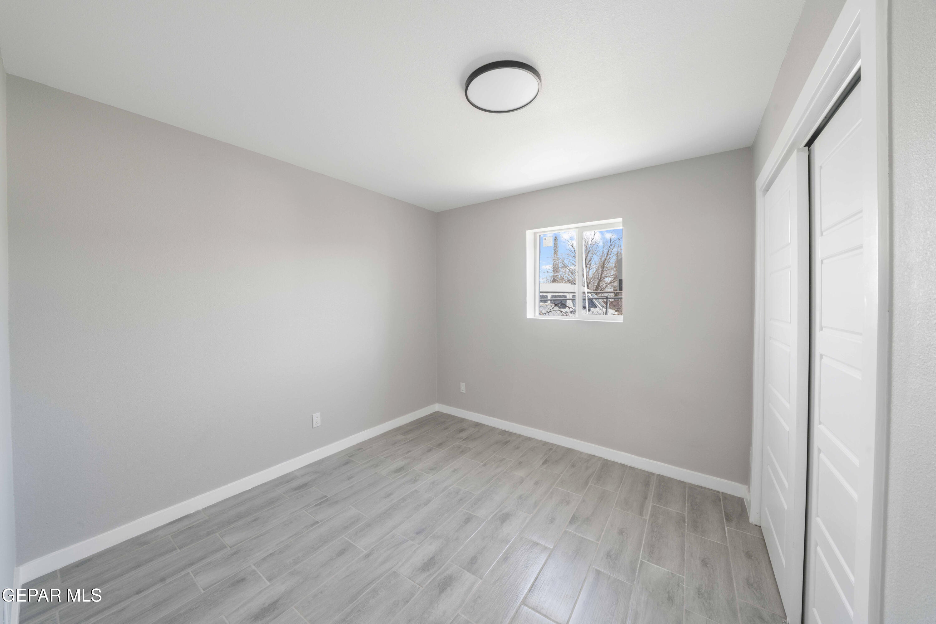 10752 Mellward Road Socorro, TX 79927 - Photo 4 of 37 an empty room with wooden floor and windows