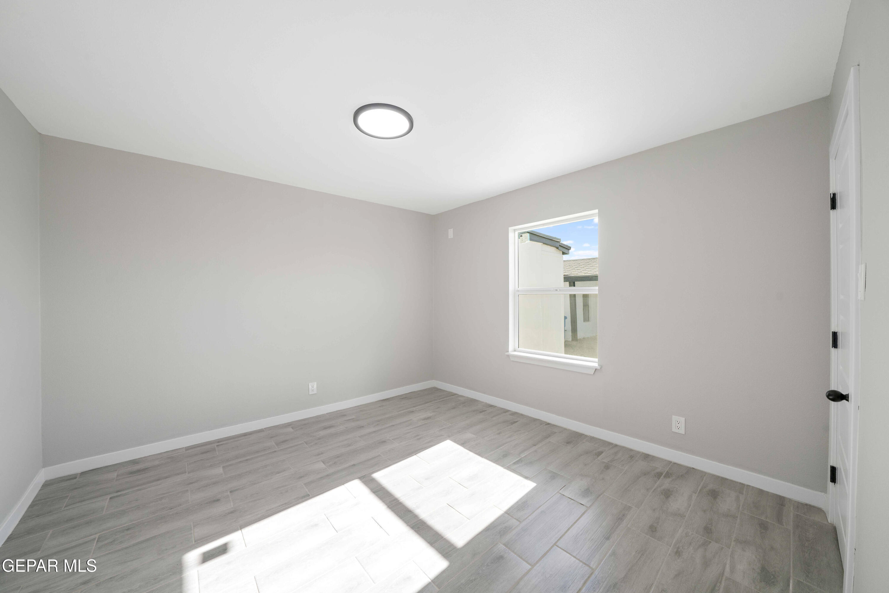 10752 Mellward Road Socorro, TX 79927 - Photo 5 of 37 an empty room with wooden floor and windows