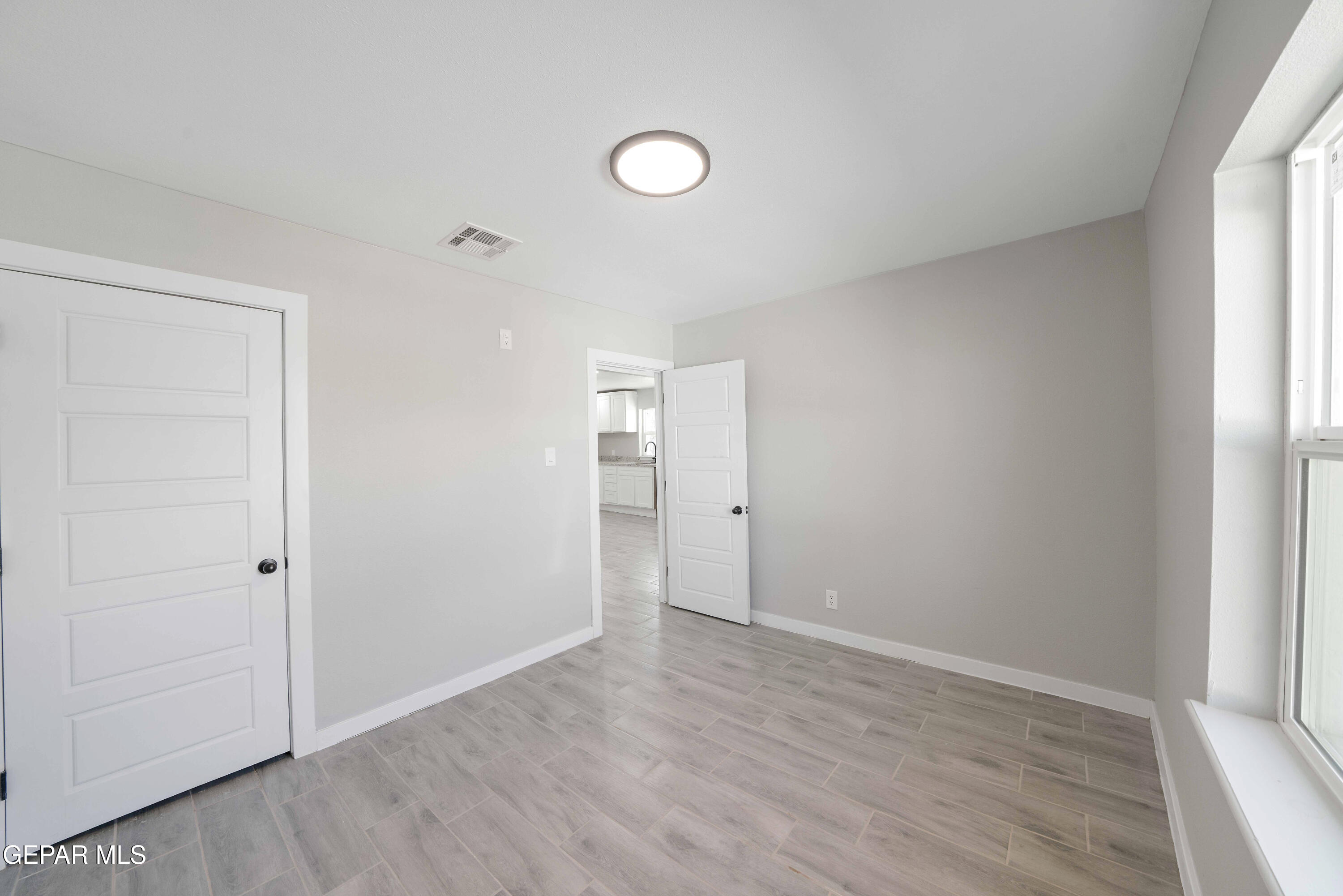 10752 Mellward Road Socorro, TX 79927 - Photo 10 of 37 an empty room with wooden floor and windows