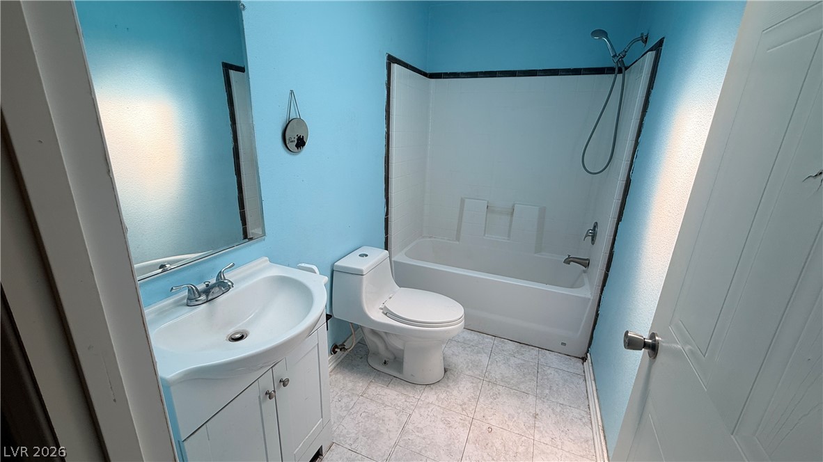 855 Spring Road Indian Springs, NV 89018 - Photo 5 of 13 Tiled flooring and a classic tub shower assembly define this functional bathroom space.