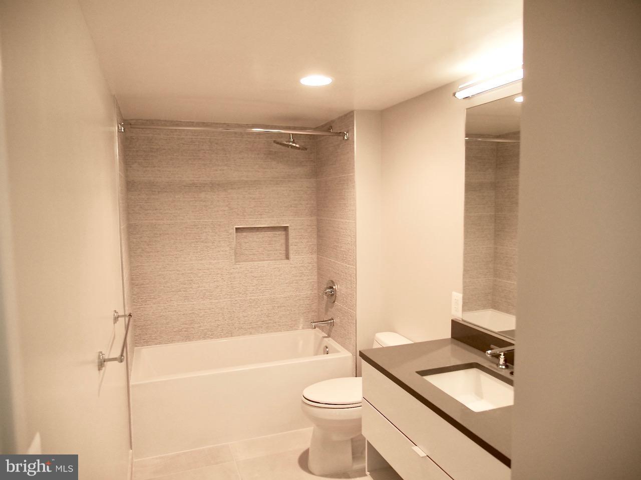 1311 13th Street Northwest, Unit 105 Washington, DC 20005 - Photo 2 of 15 a bathroom with a granite countertop sink toilet and shower