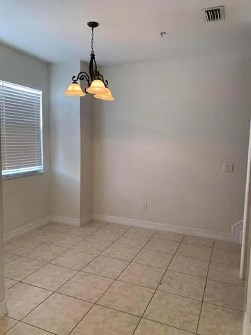 an empty room with chandelier fan
