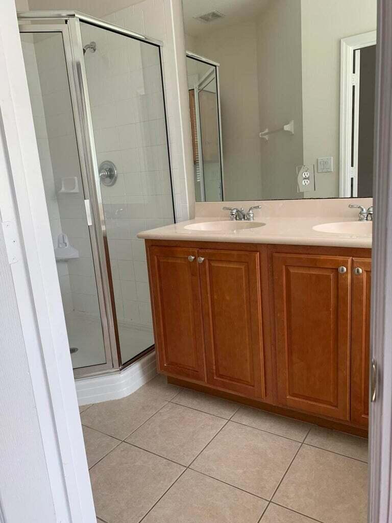 125 Harbors Way Boynton Beach, FL 33435 - Photo 17 of 37 a bathroom with a sink a mirror and a shower