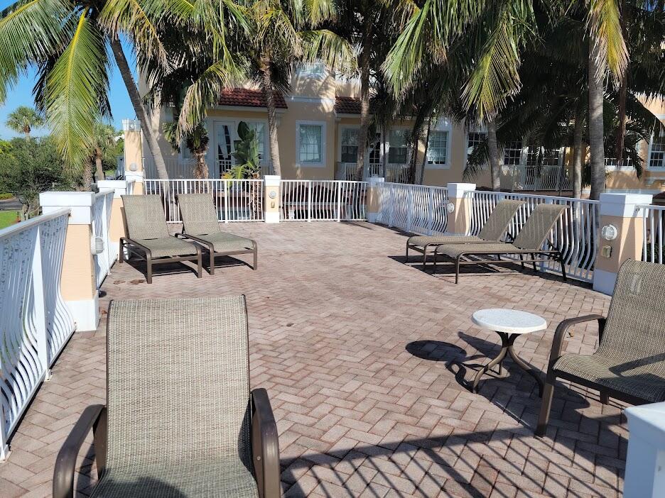 125 Harbors Way Boynton Beach, FL 33435 - Photo 26 of 37 a view of a patio with table and chairs with wooden fence and large trees