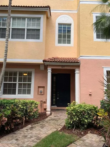 a view of a house with potted plants and a yard