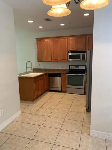 a kitchen with stainless steel appliances a sink a stove a microwave and cabinets