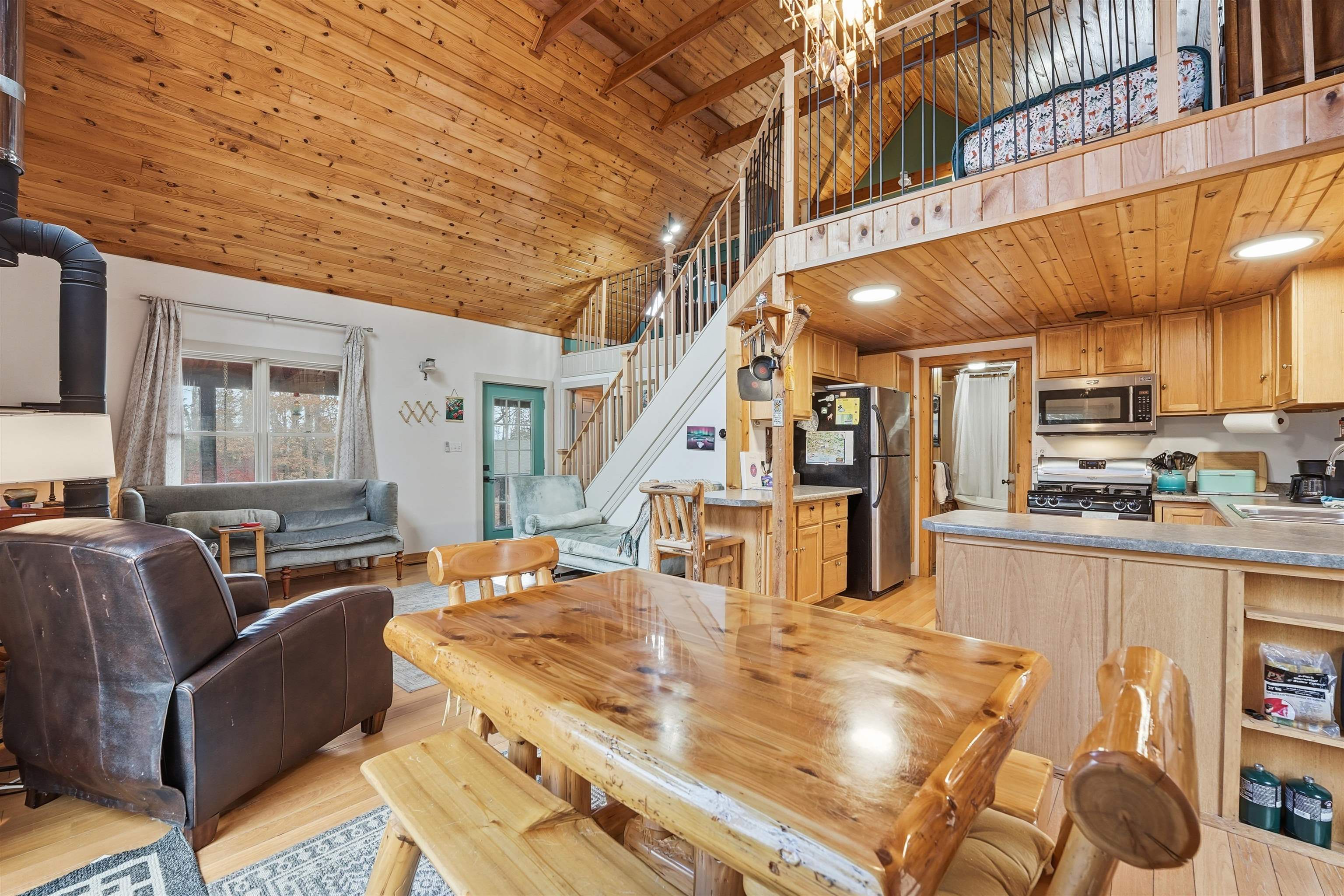 85255 Ravine Road Port Wing, WI 54865 - Photo 10 of 38 Dining area with a wooden ceiling with exposed beams, stairway, high vaulted ceiling, and light wood-style floors
