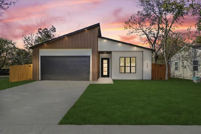 a front view of a house with a garden and yard