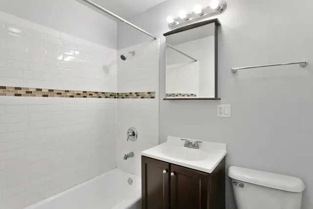 a bathroom with a sink mirror toilet and bathtub