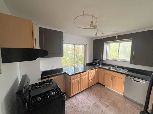 a kitchen with granite countertop a sink stove and cabinets