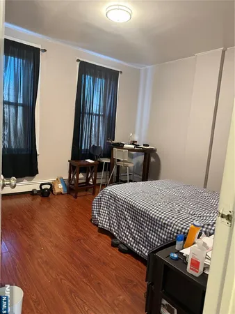 a bedroom with bed and wooden floor
