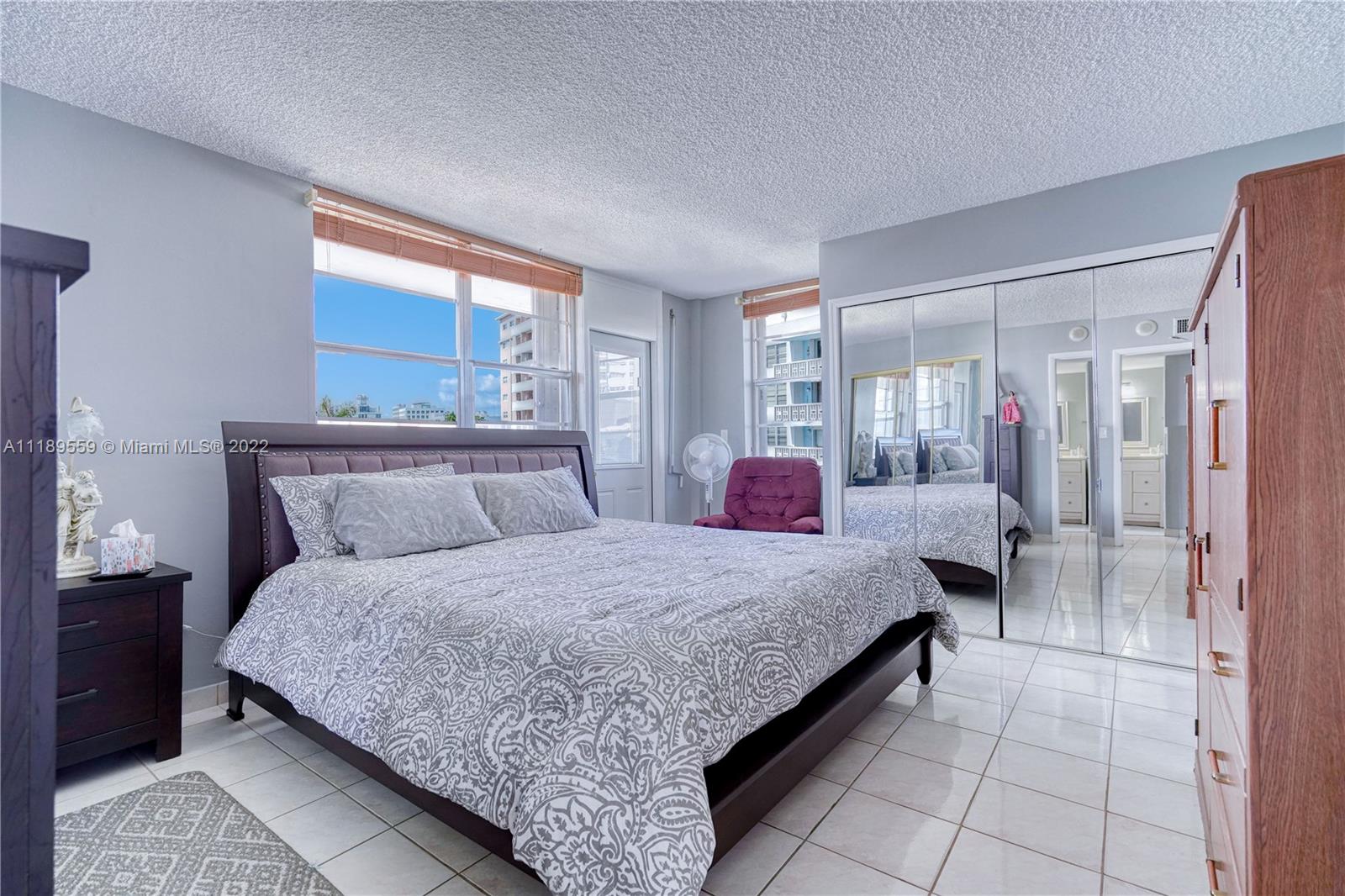 245 18th Street, Unit 602 Miami Beach, FL 33139 - Photo 15 of 40 a bedroom with a large bed and a chandelier