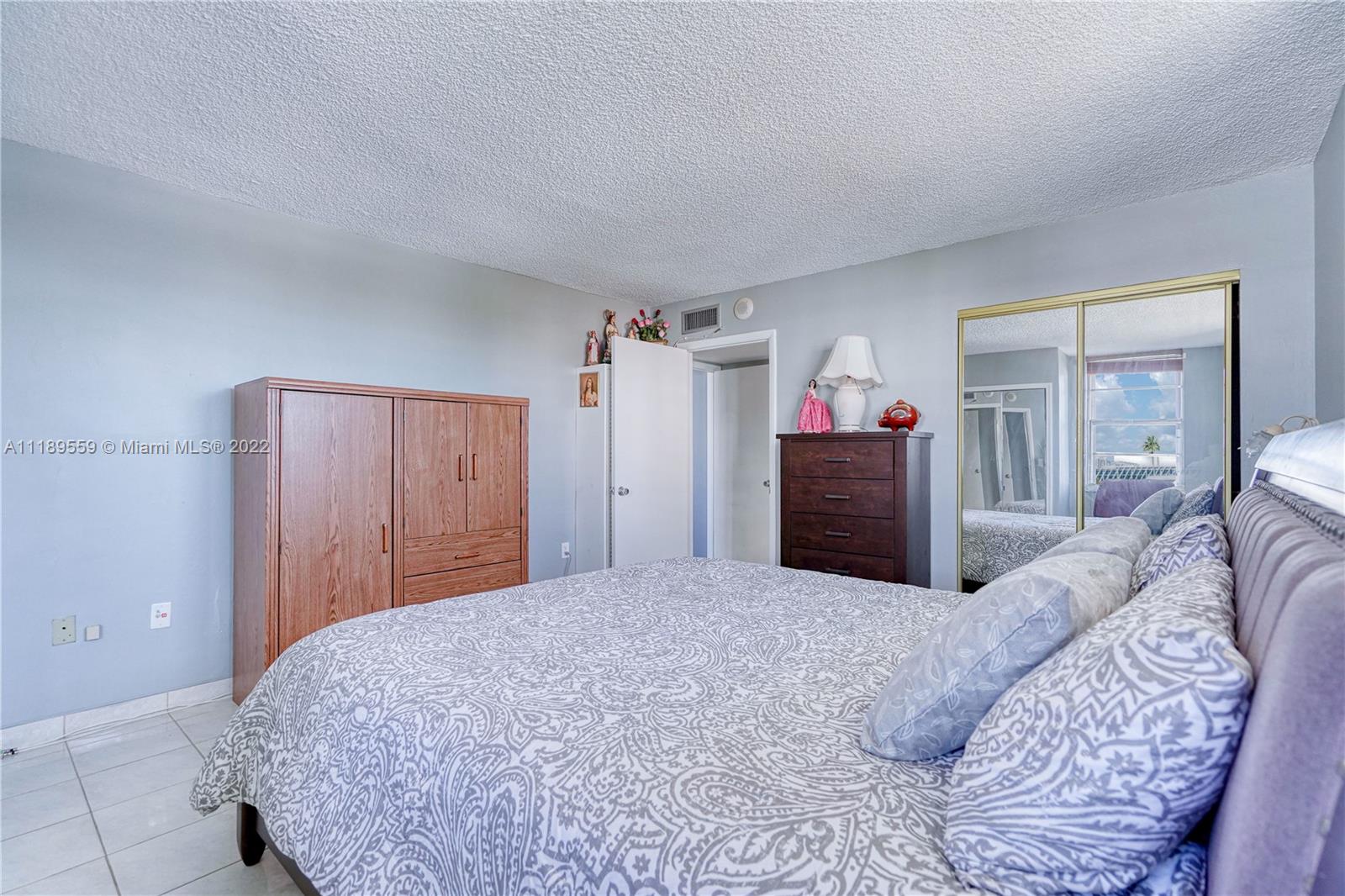 245 18th Street, Unit 602 Miami Beach, FL 33139 - Photo 17 of 40 a bedroom with a large bed and a dresser