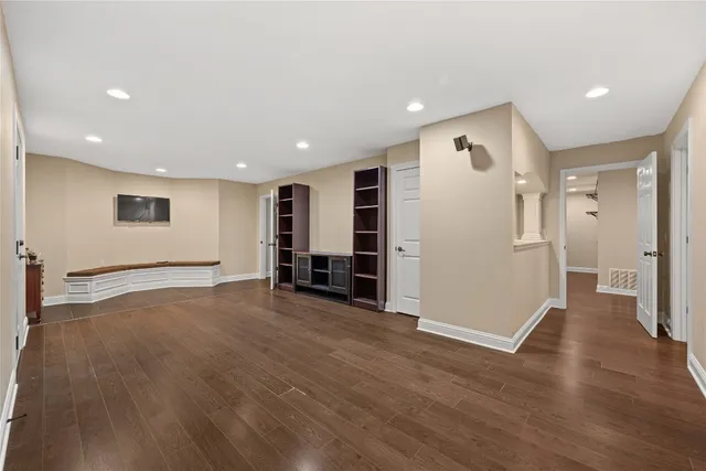 a view of empty room with wooden floor