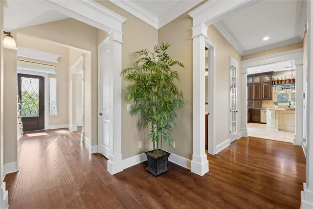 a view of a hallway with wooden floor and a dining room
