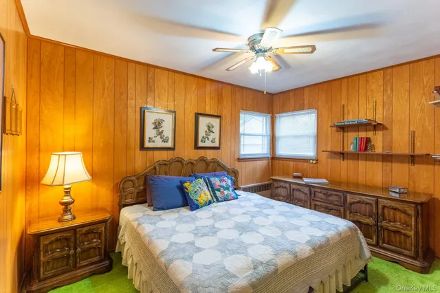 a bedroom with a bed and dresser with mirror