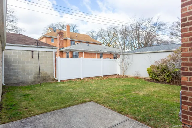 a backyard of a house with plants and barbeque oven