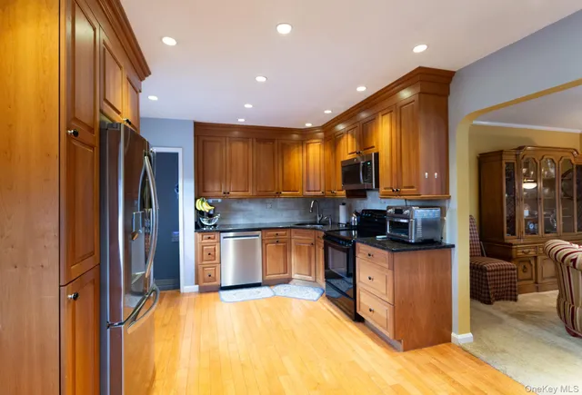 a kitchen with stainless steel appliances granite countertop a refrigerator and a stove top oven