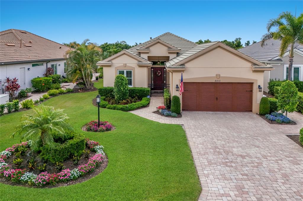 5011 Tobermory Way Bradenton, FL 34211 - Photo 32 of 77 a front view of a house with a garden and plants