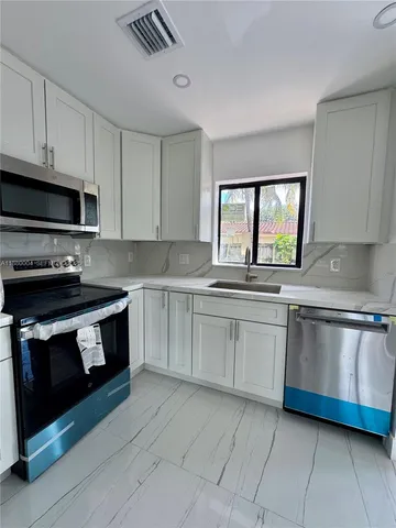 a kitchen with stainless steel appliances granite countertop a sink and a stove