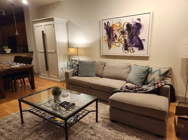 a living room with furniture and a painting on the wall