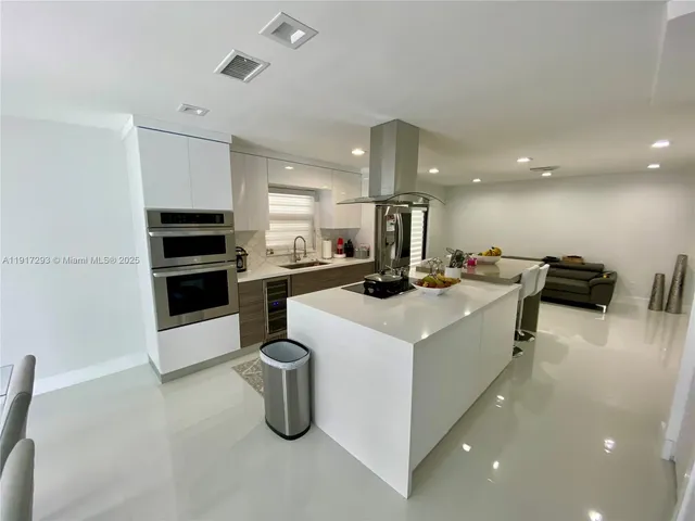 a kitchen that has a lot of cabinets a sink and appliances