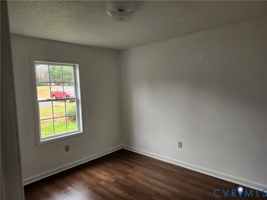 331 Stoney Point Road Cumberland, VA 23040 - Photo 8 of 10 an empty room with wooden floor and windows