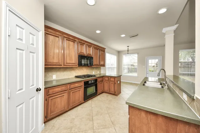 a large kitchen with stainless steel appliances lots of counter space and windows