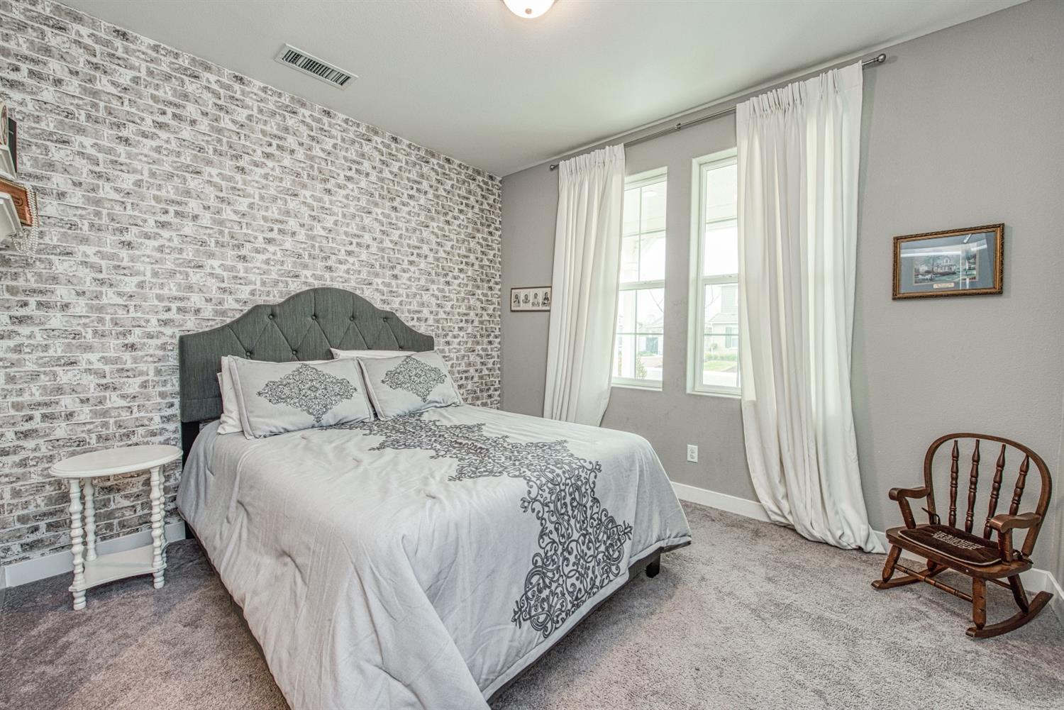 333 Meridian Avenue Madera, CA 93636 - Photo 17 of 38 a large bed sitting in a bedroom next to a window with chair