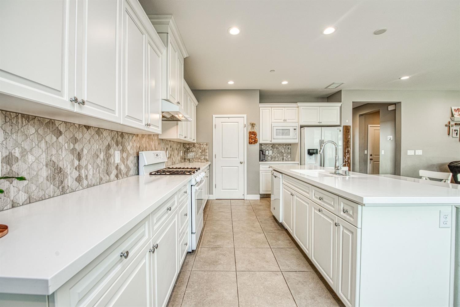 333 Meridian Avenue Madera, CA 93636 - Photo 5 of 38 a large kitchen with stainless steel appliances granite countertop a sink and cabinets