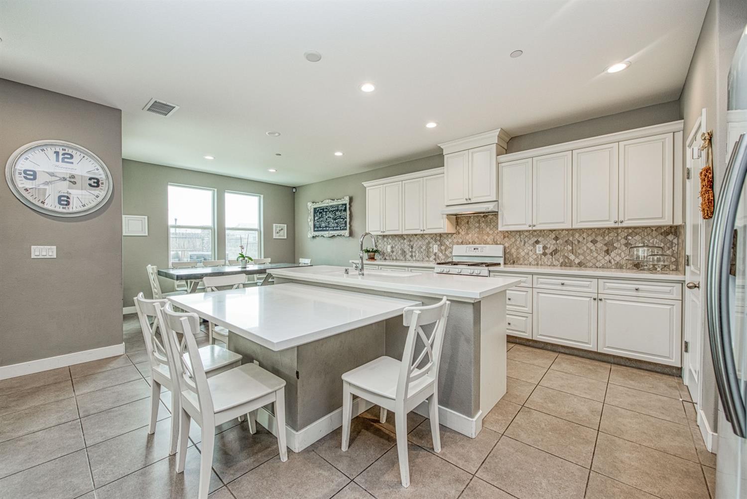 333 Meridian Avenue Madera, CA 93636 - Photo 6 of 38 a kitchen with a dining table chairs cabinets and stainless steel appliances
