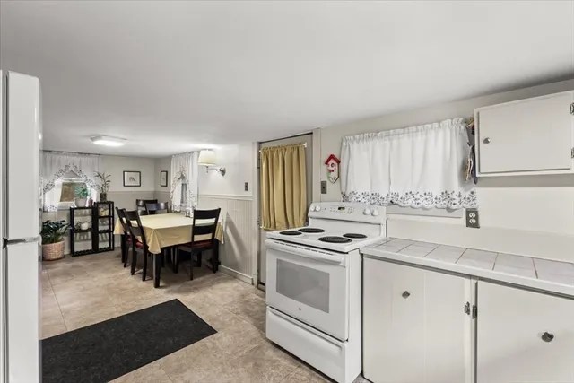 a kitchen with stainless steel appliances a refrigerator a stove and white cabinets